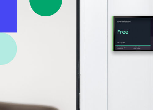 Joan 6 Pro e-ink display mounted beside office door showing conference room availability status as Free.