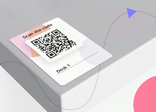 QR code label reading 'Scan the code' and 'Desk 1' placed on a desk corner for easy booking.