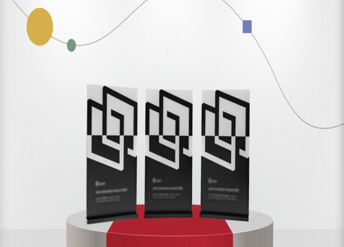 Three Joan Innovation Award 2023 trophies displayed on a circular pedestal with geometric black and white design.
