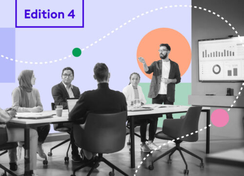 Diverse team in a meeting room with a presenter and data dashboard on screen — Joan Magazine Edition 4.
