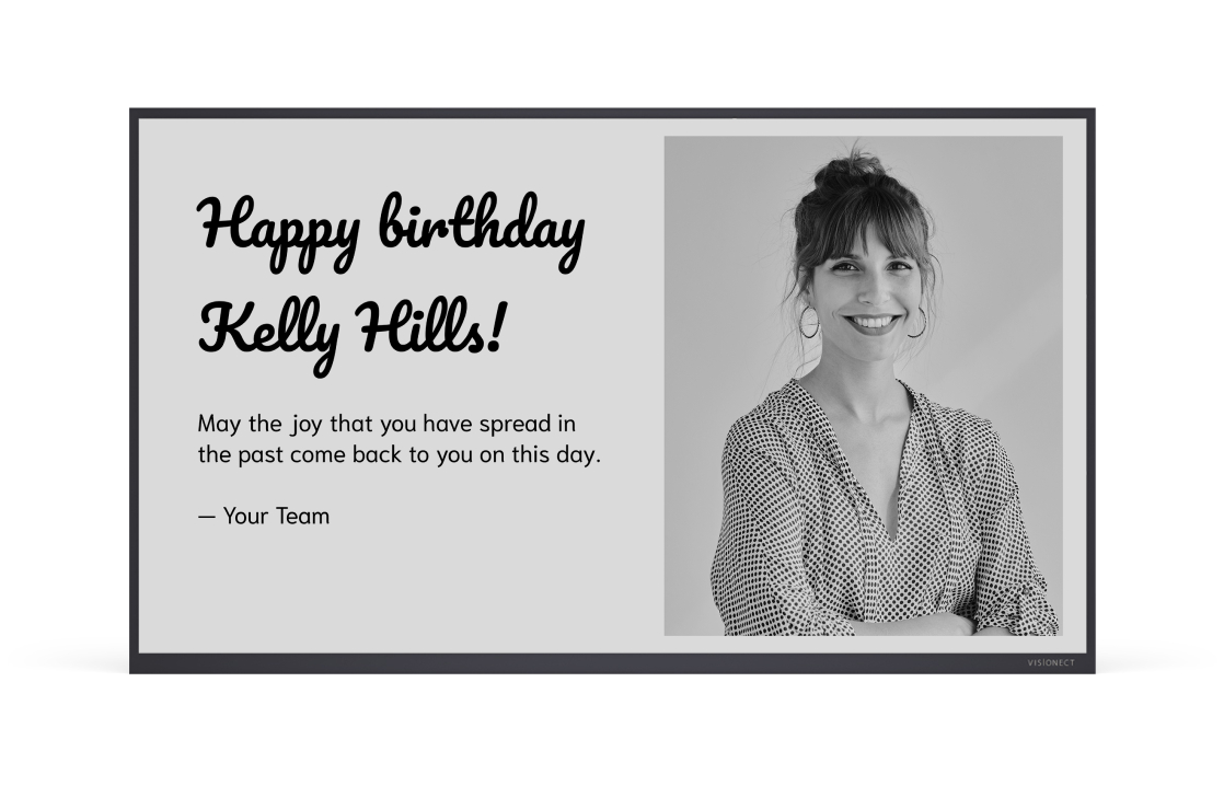 E-ink display showing a birthday greeting for Kelly Hills with a smiling employee photo and a team message.